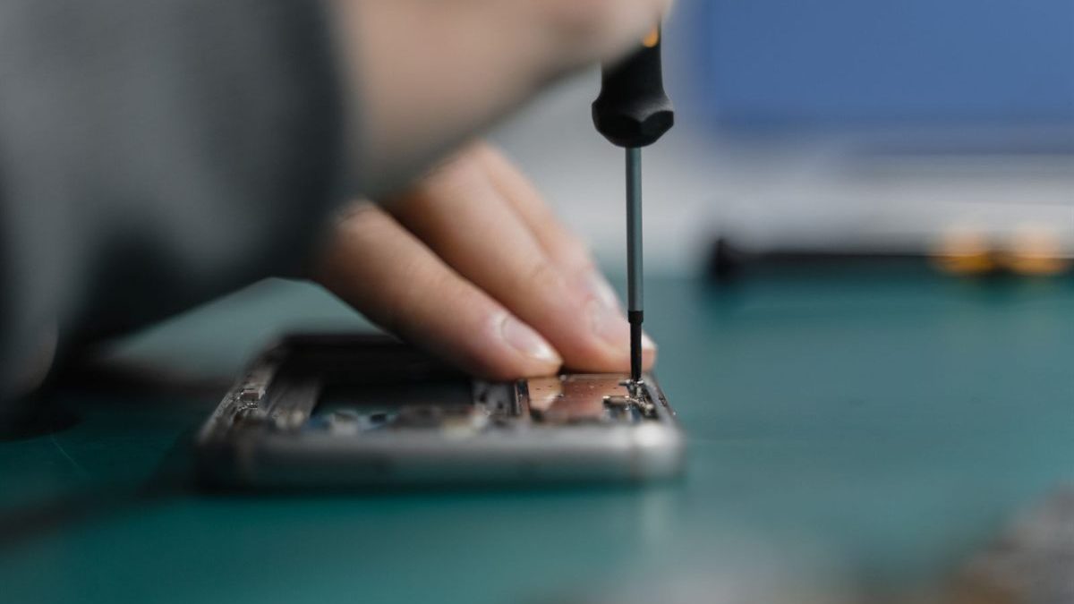 Τεχνικός αποσυναρμολογεί συσκευή στον πάγκο